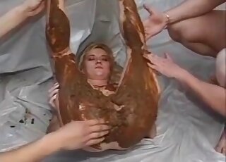 Two horny men are smearing feces all over the thick blonde